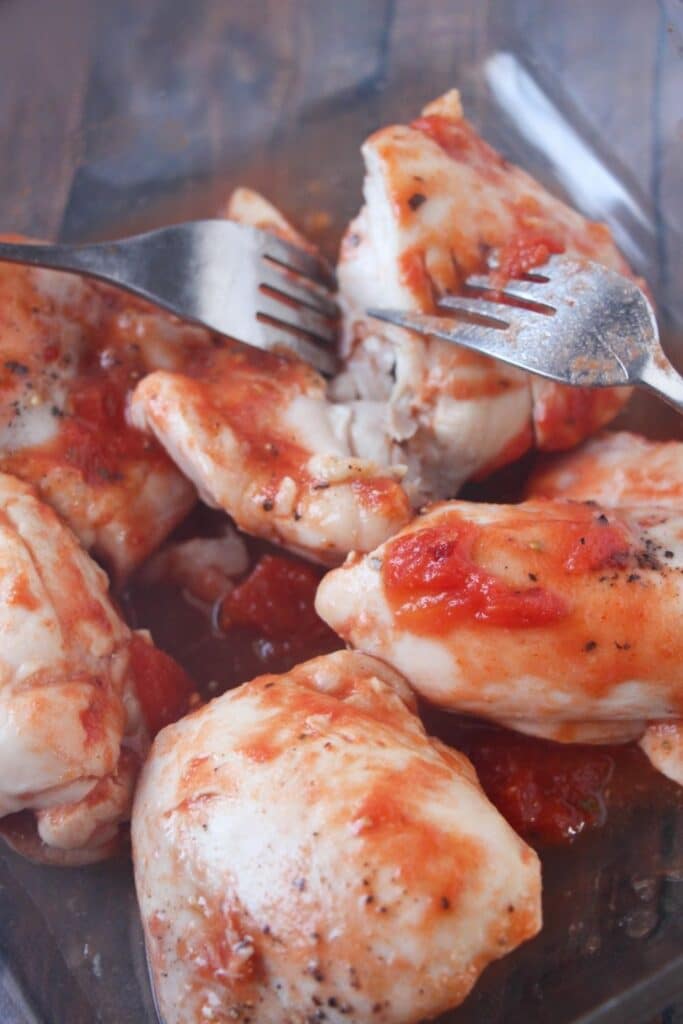 shredding chicken on cutting board 