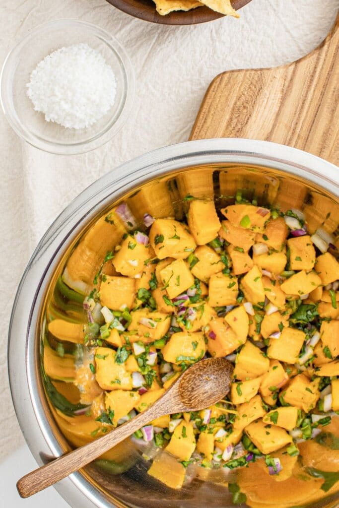 mango mixture in a metal bowl on counter with salt by it 