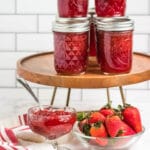 strawberry jam on counter with bowl of jam and berries