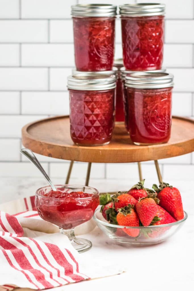 strawberry jam on counter with bowl of jam and berries 