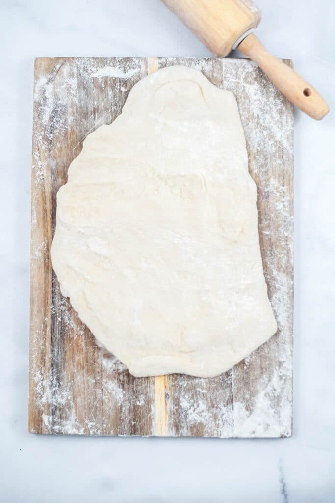 rolled out dough on cutting board