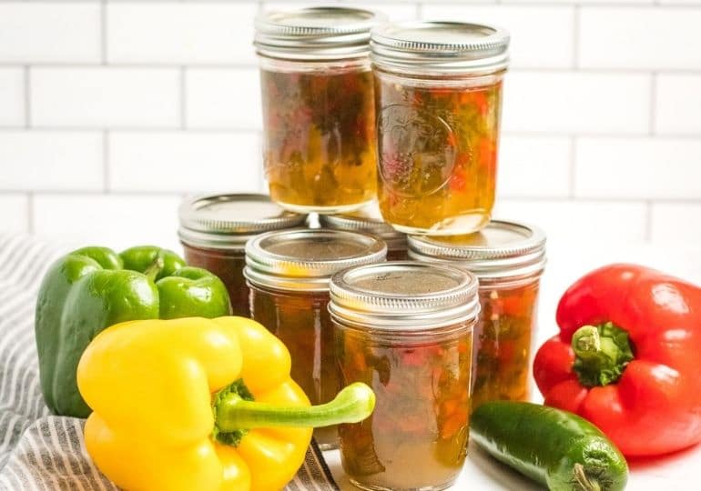 jars of pepper jelly with peppers around it