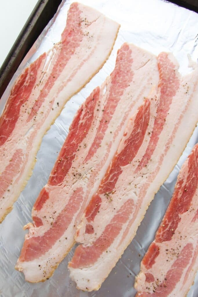 bacon on a baking sheet with aluminum foil on pan 