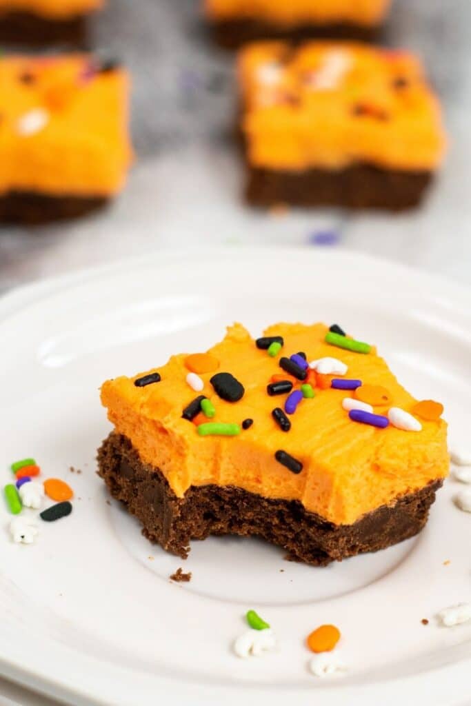 bitten cookie bar on plate with cookies bars behind it 