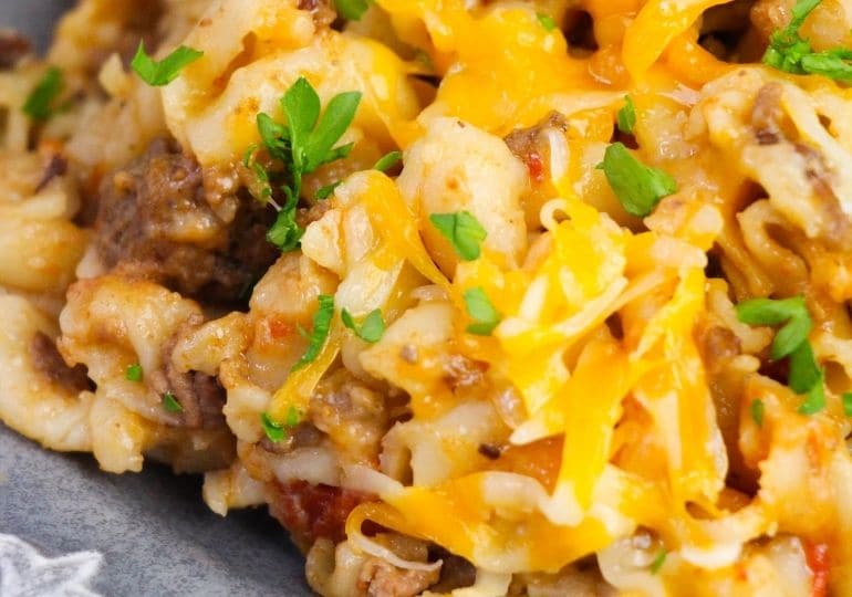 plate full of cheesy pasta and ground beef with garnish