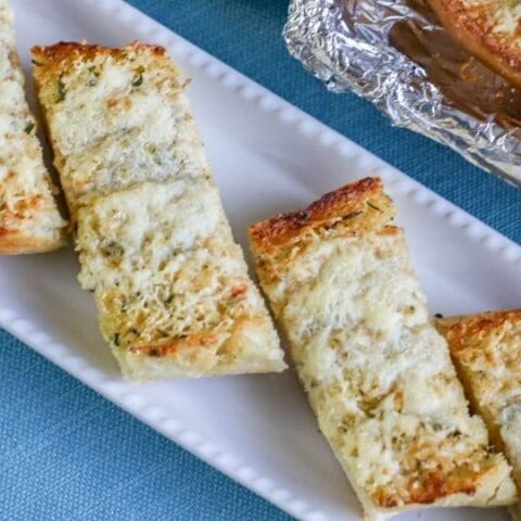 sliced garlic bread on rectangle platter on table