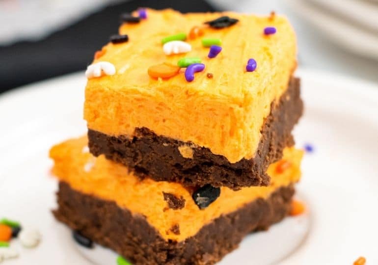 stacked cookie bars on white plates on table 