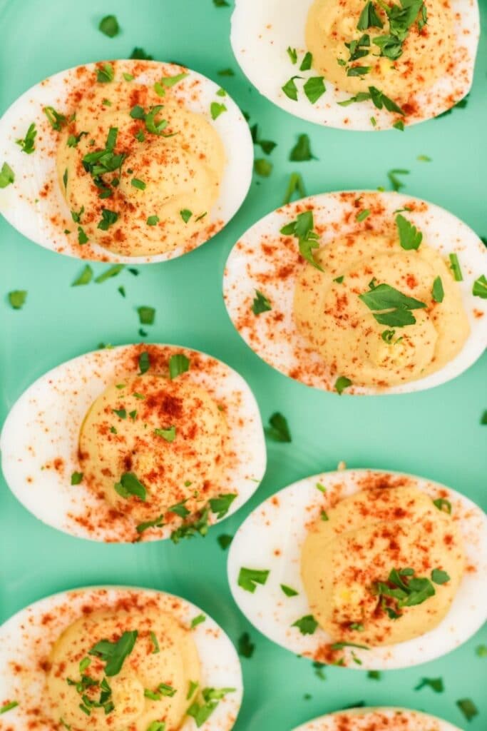 hummus filled eggs on a green platter on table 