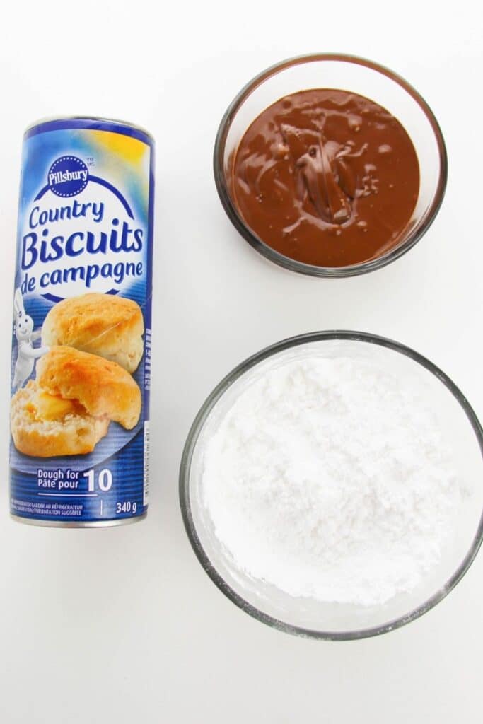 biscuits, nutella and powdered sugar on white counter 