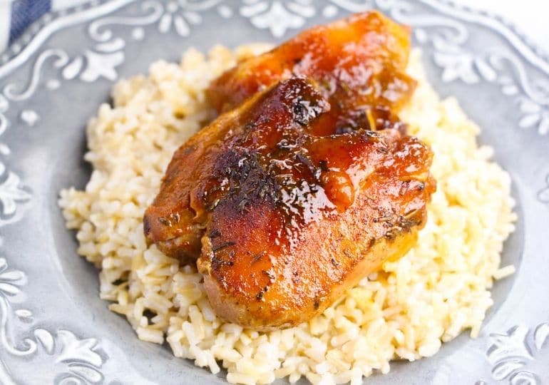 chicken thigh on plate with rice under it