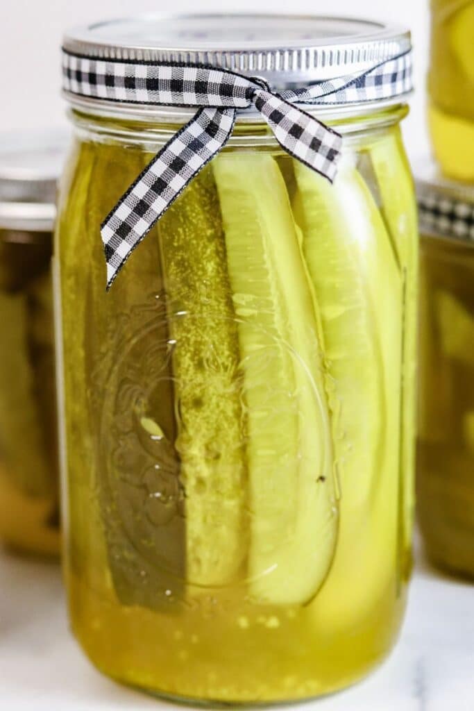 dill spears in a mason jar with ribbon on it 