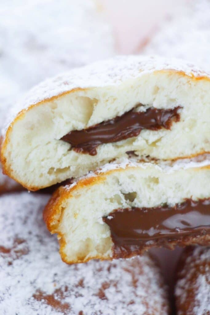 donut cut in half with hazelnut spread coming out of it 