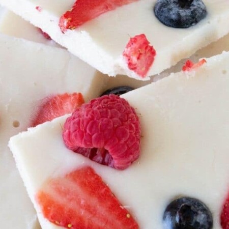 cut up frozen yogurt bark with berries on it