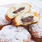 donuts on a plate with one cut in half