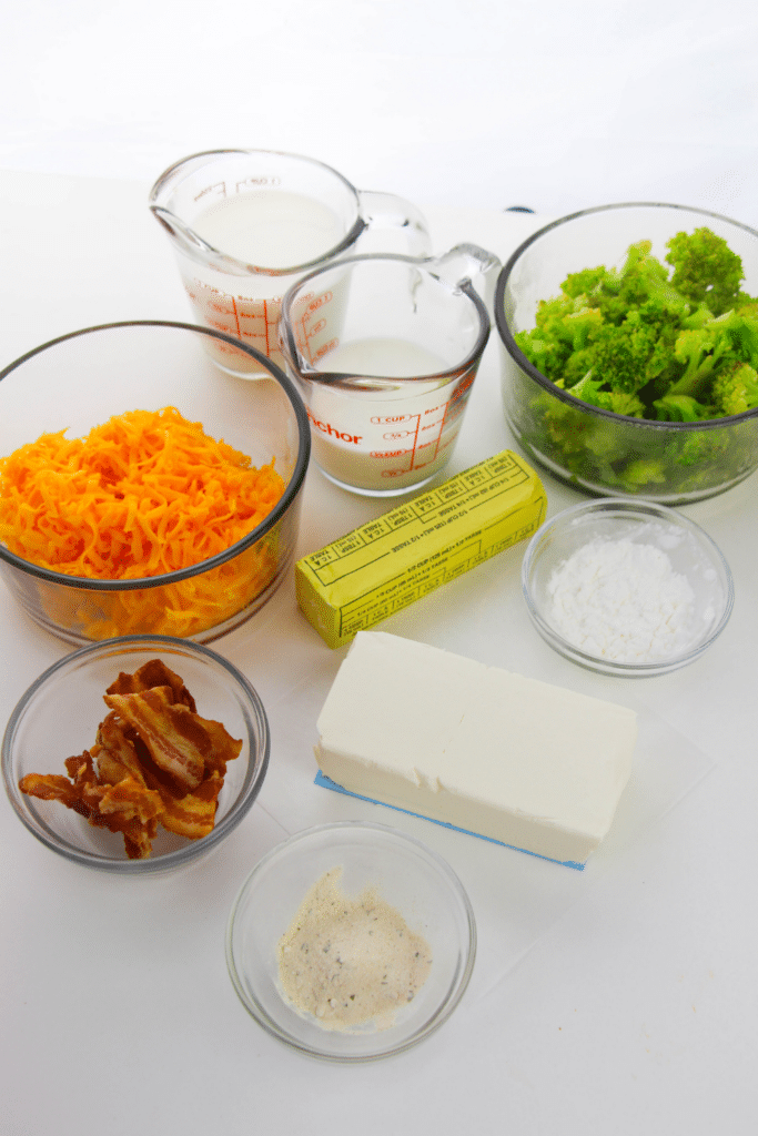 ingredients for a broccoli casserle in their own containers on white table