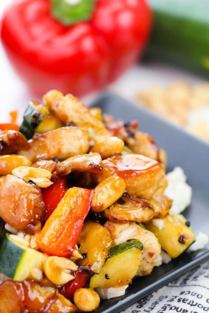 Chinese Chicken on plate with red pepper behind it 