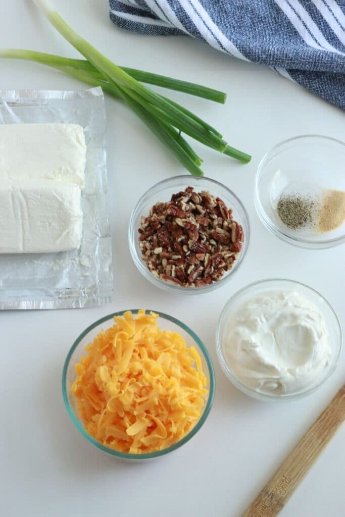 cheese ball ingredients on a white table with towel behind it 