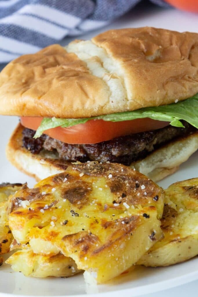 burger and smash potatoes on a white plate