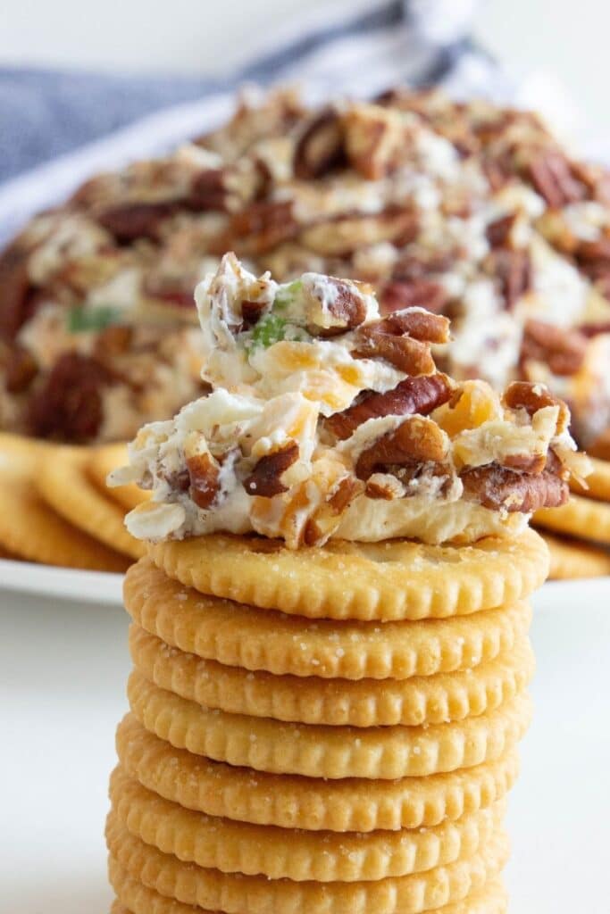 cheese ball dollop on top of a stack of crackers 