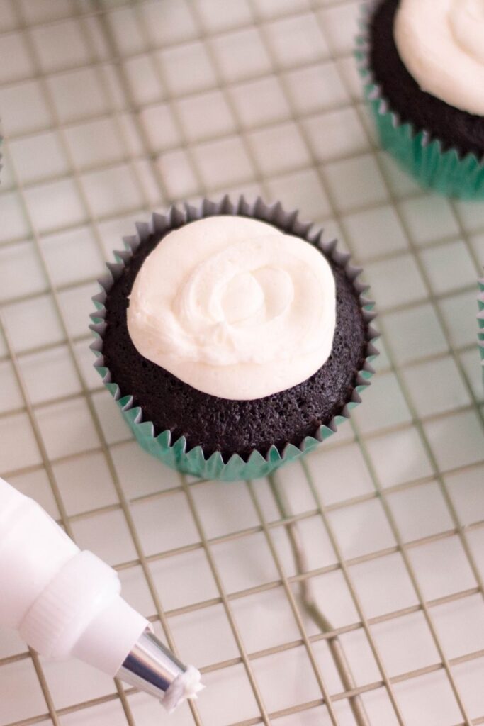 chocolate cupcake on baking rack frosted. 