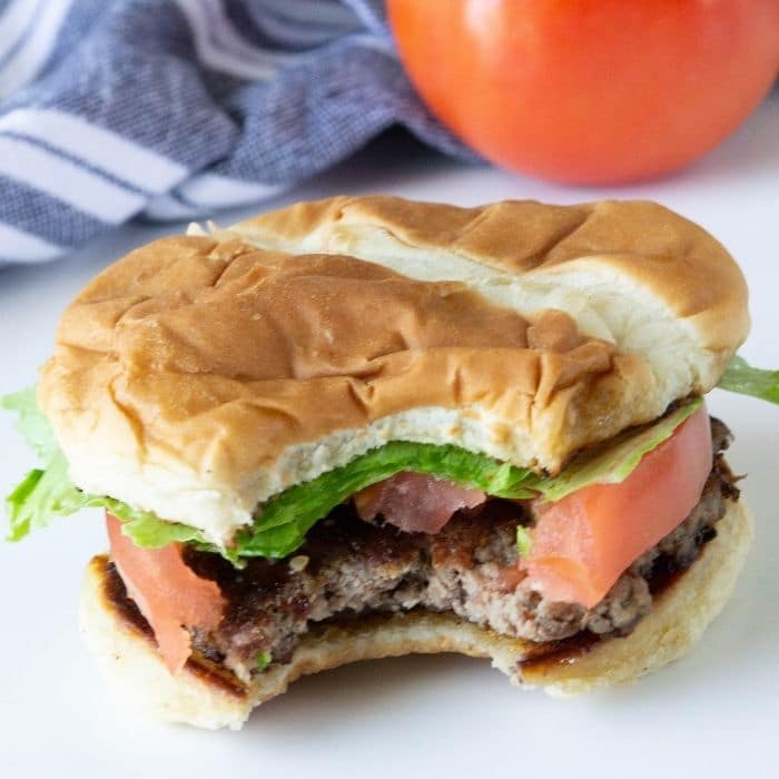 burger on a plate with bite taken out