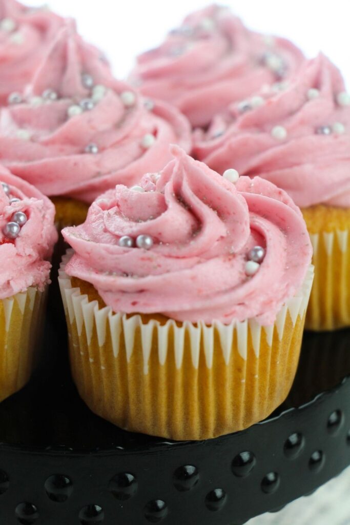 pink cupcakes with sprinkles on stand