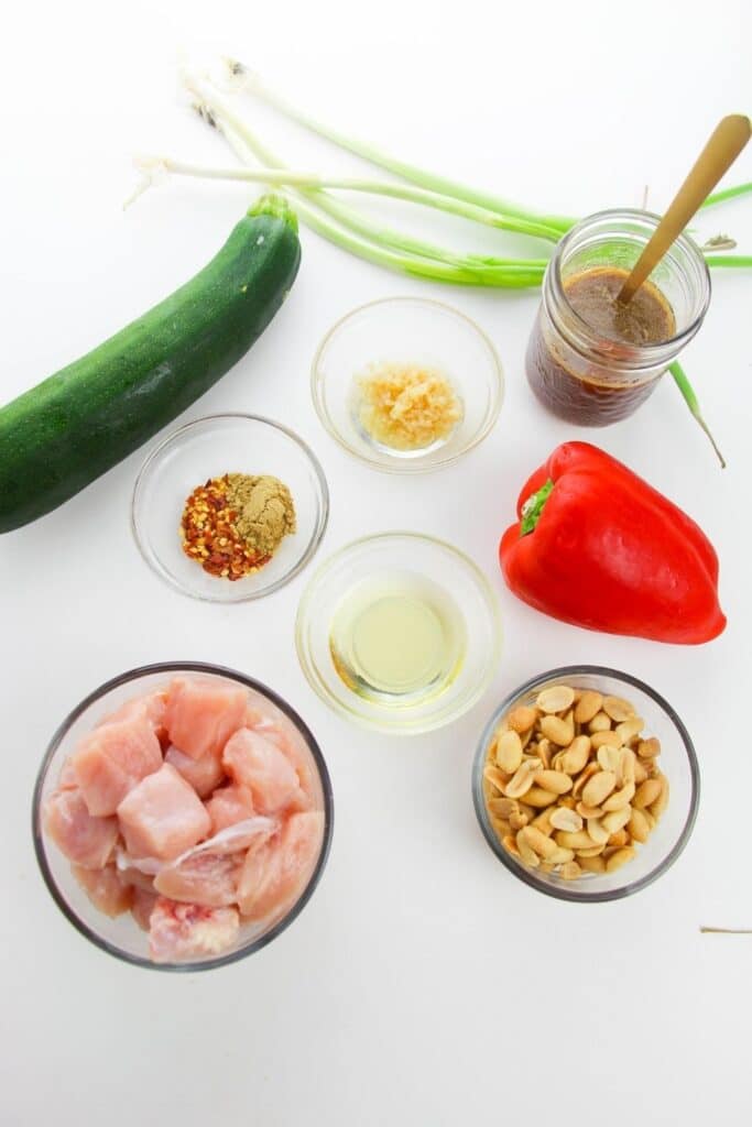 ingredients for kung pao chicken in glass bowls on counter 