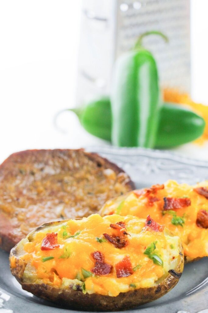 twice baked potatoes with steak on side of plate 