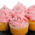 plate of cupcakes with pink frosting