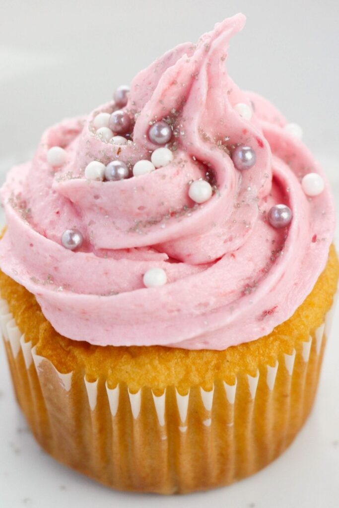 pink frosted cupcake on counter 