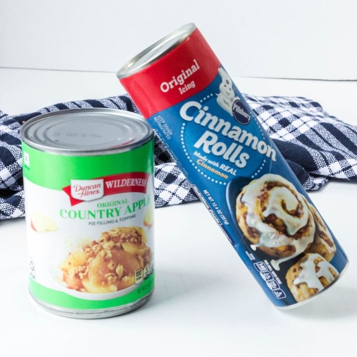 apple pie filling and cinnamon roll containers on white counter 