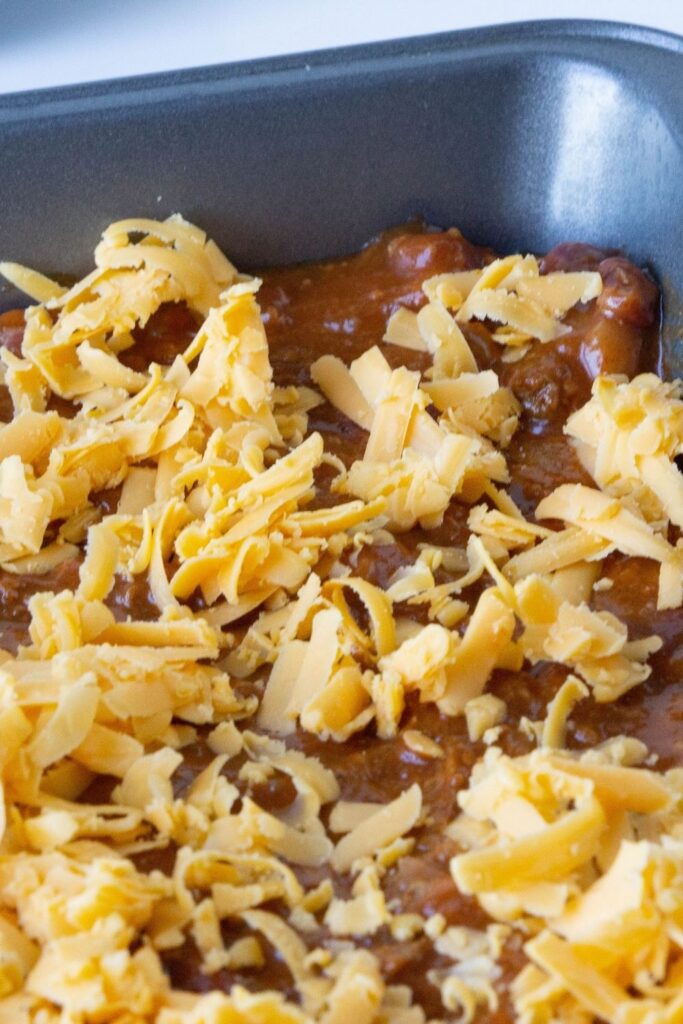 chili in a pan with shredded cheese on top 