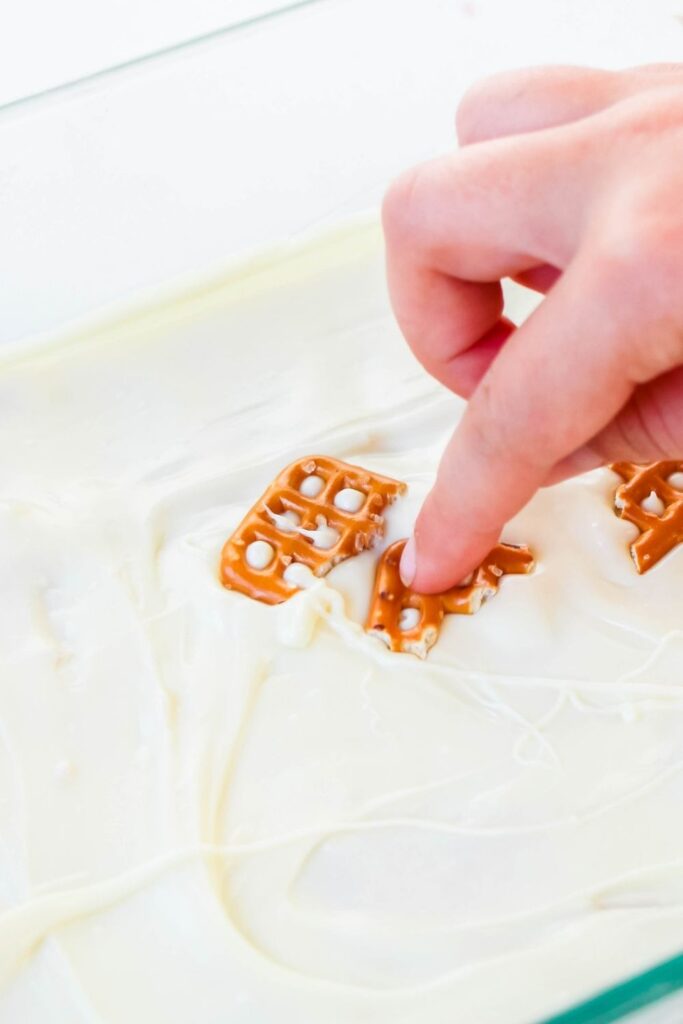 pressing pretzels into fudge 