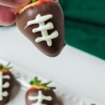 holding a dipped strawberry in hand