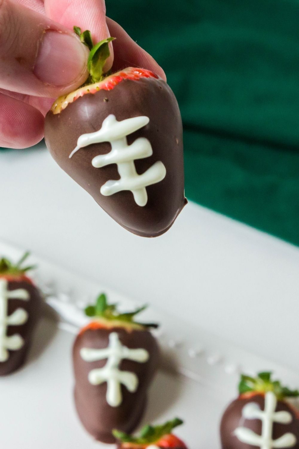 holding a dipped strawberry in hand