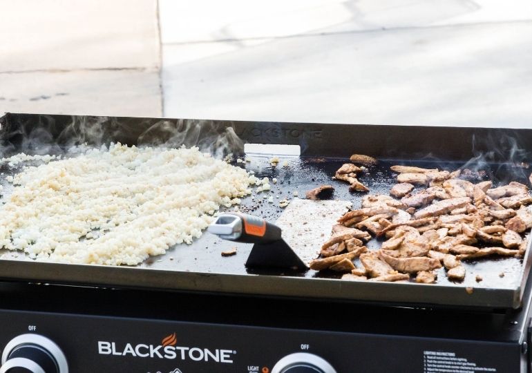 chicken and cauliflower rice cooking on blackstone grill