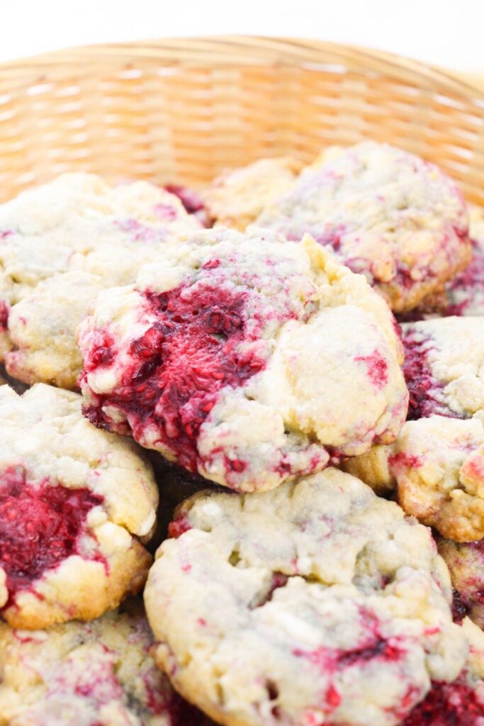 side shot of raspberry white chocolate cookies in wooden basket