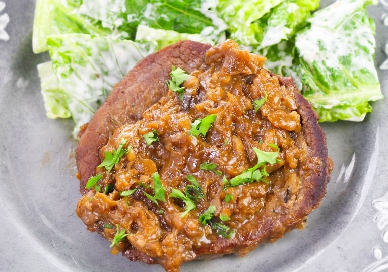 smothered steak on plate with salad