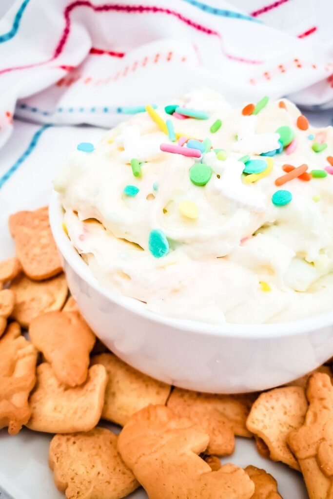 side view of dip in a bowl with cookies around it 