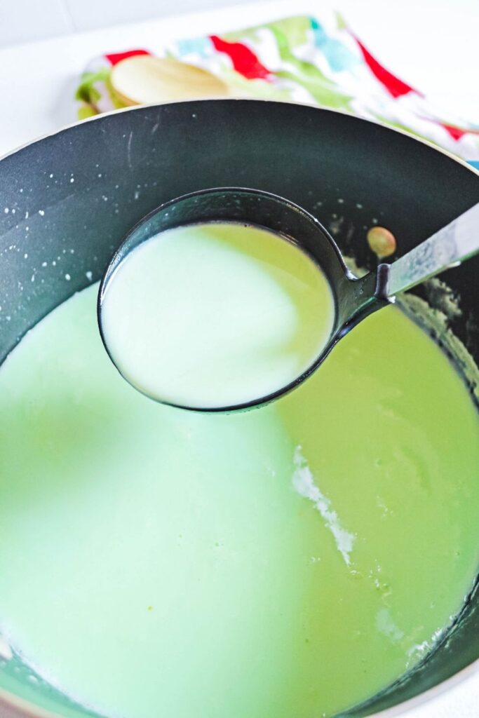 ladle full of green hot chocolate over the pot 