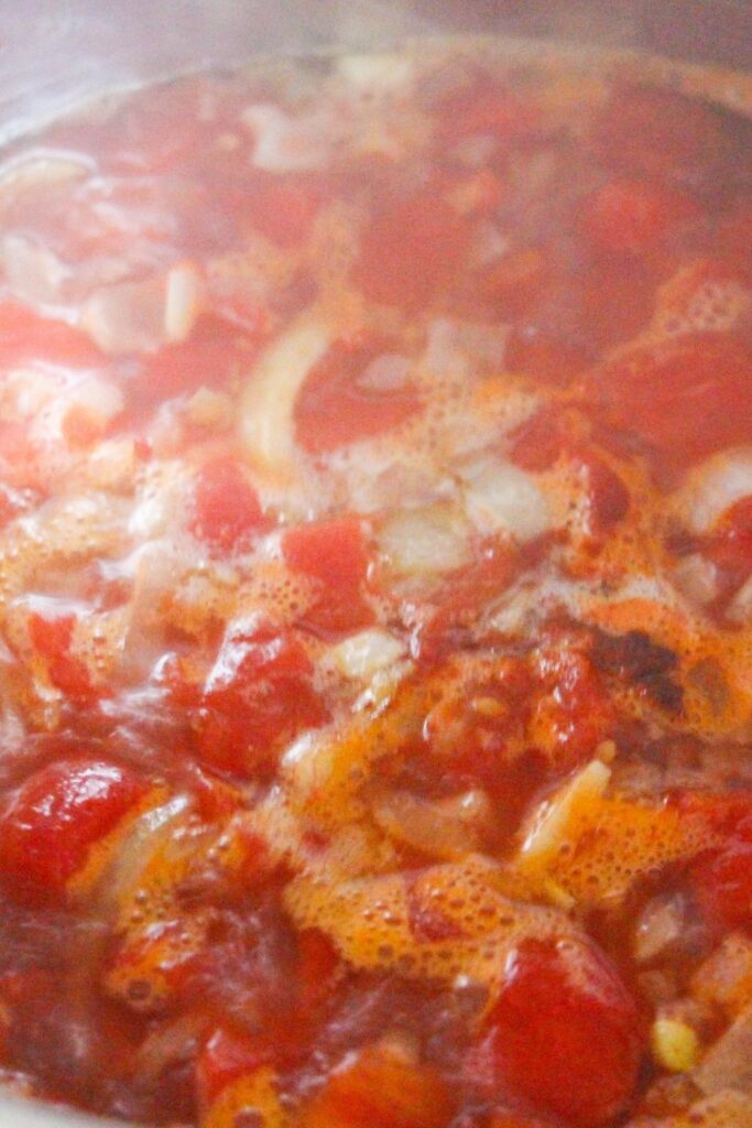 cooking tomato soup in pot on stovetop 