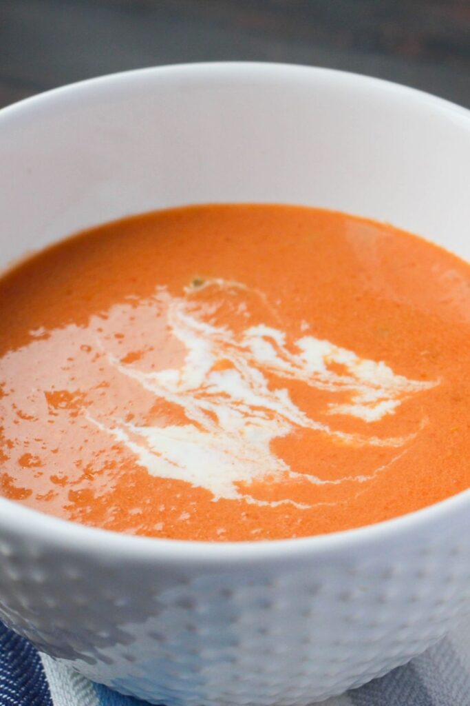 creamy roasted tomato soup in a white bowl 