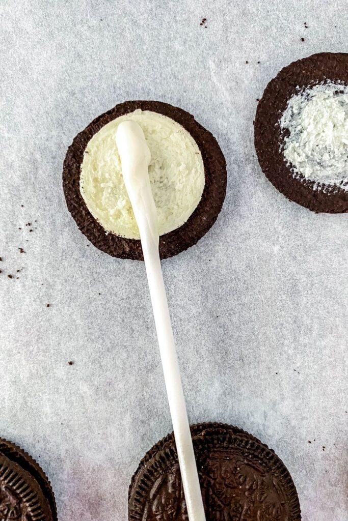 stick in center of Oreo with white chocolate on it 