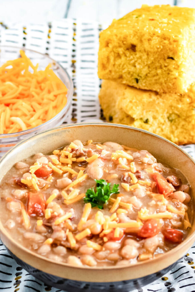 bean with bacon soup with cornbread behind it on counter 