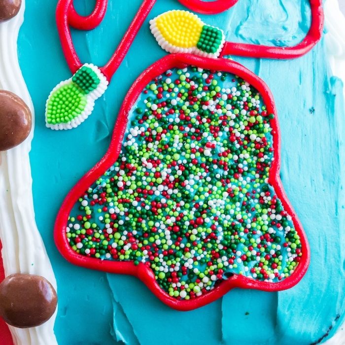 bell in sprinkles with icing around it on cake