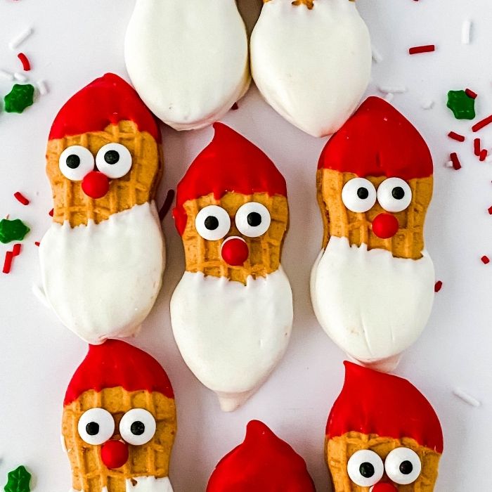 santa claus cookies on white counter with sprinkles