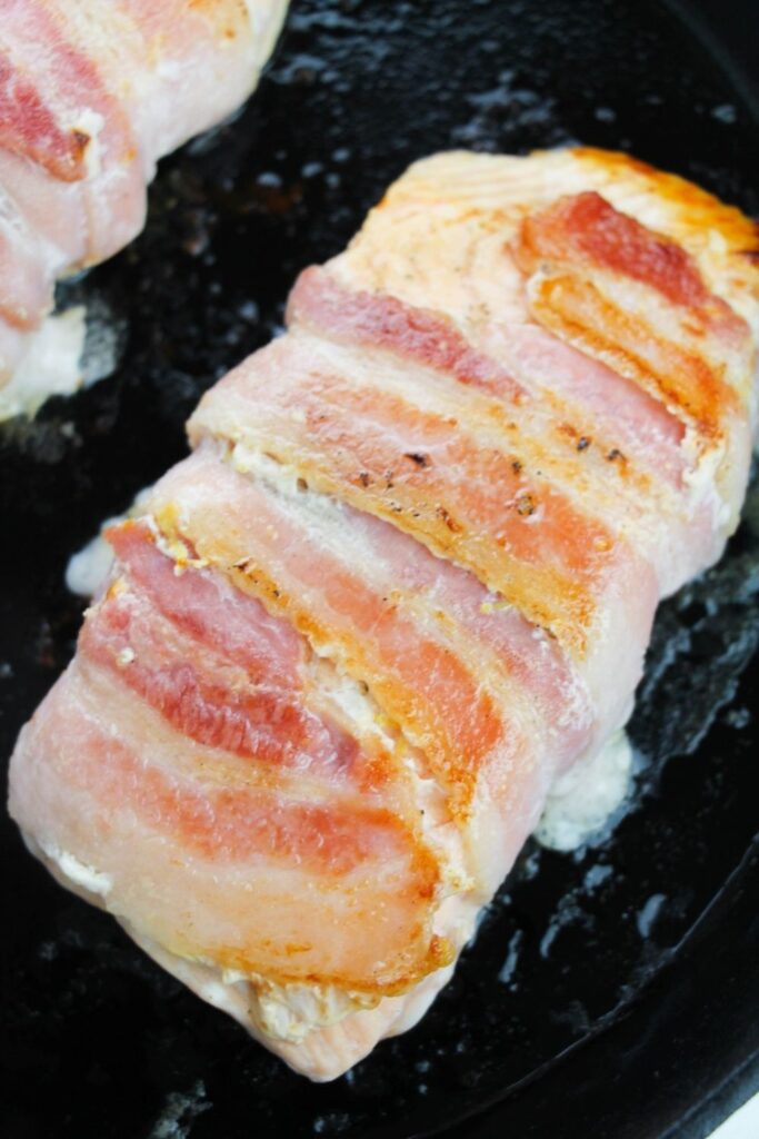 salmon with seared bacon wrapped around it 