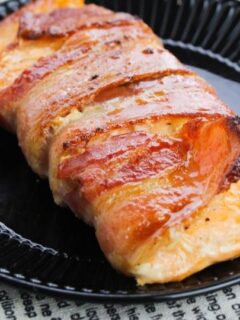 bacon wrapped salmon on black plate