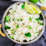 bowl of cilantro lime rice in a bowl with lime wedges on side