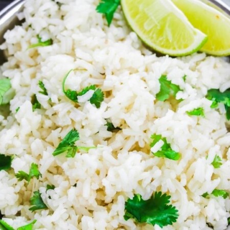 cilantro lime rice in a bowl with lime wedges on side